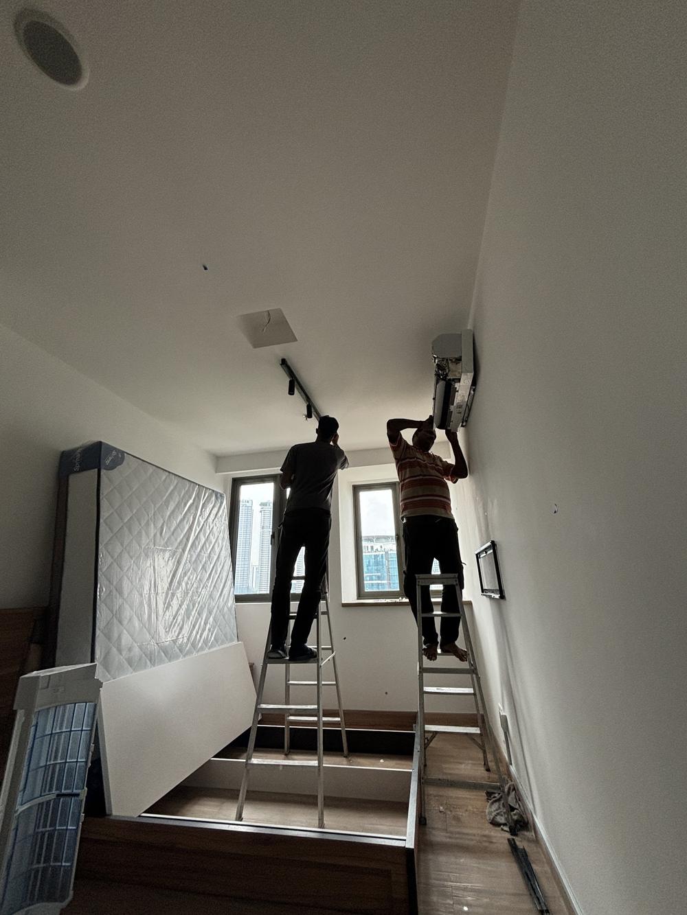 Two electricians on ladders